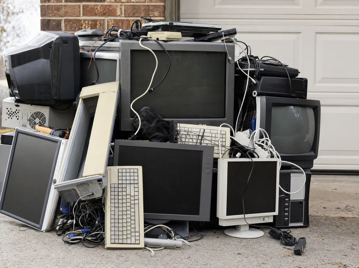 Old televisions, monitors and electronics stacked for e-waste removal