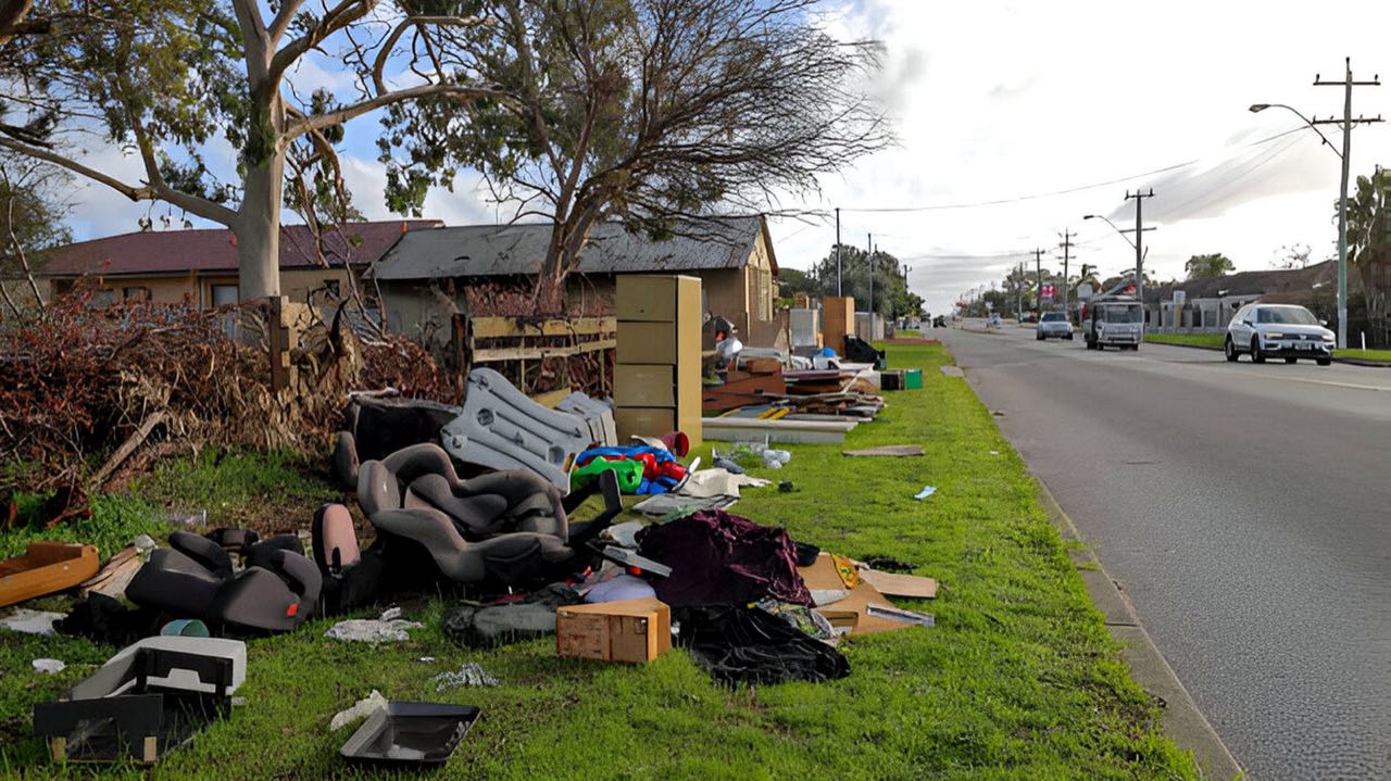 A whole curbside packed with furniture, mattresses and boxes before Buddies hauled it away