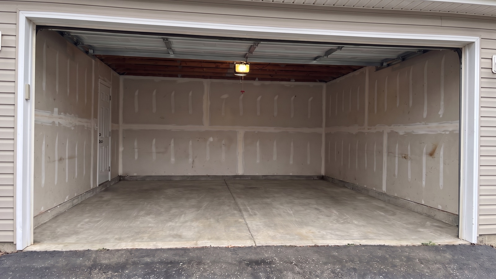 An empty two-car garage with a swept concrete floor after the cleanout